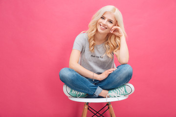 Smiling blonde woman sitting on the chair