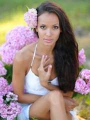 Fototapeta premium portrait of a beautiful girl with flowers in the summer