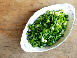 fresh spring onion chopped green onions on wooden background