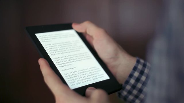A man rotate an ebook on his tablet computer indoor in home. Book contents are from my own ebook.