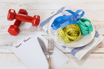 Fitness concept with dumbbells and measuring tape