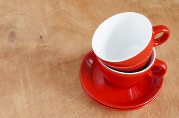 Home Kitchen Decor: the ceramic red cups on a wooden background. 