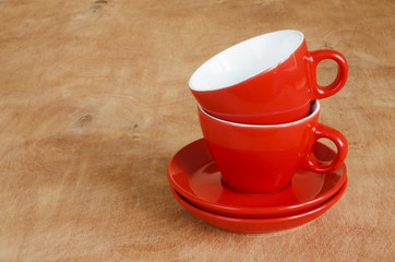 Home Kitchen Decor: the ceramic red cups on a wooden background. 