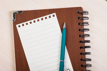 Blank note paper with pen on wood background