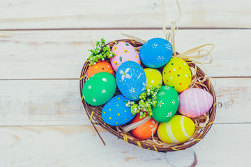 Easter eggs painted in pastel colors on white wooden background.