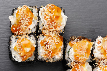 Set of yummy sushi rolls with cream cheese and caramel sauce