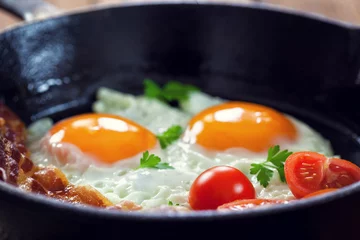 Photo sur Plexiglas Oeufs sur le plat Bacon et oeufs avec des tomates pour le petit déjeuner