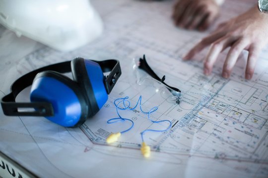 Close up of male hands on blueprint in construction site