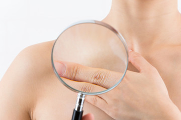 虫めがねを鎖骨にあてる女性