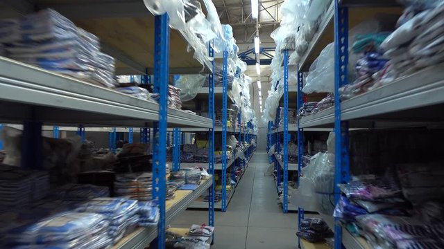 Big textile warehouse shelves smooth steadicam 4K shot