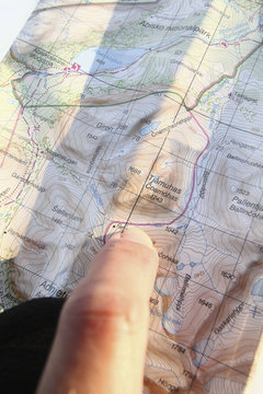 Finger pointing on map, close-up