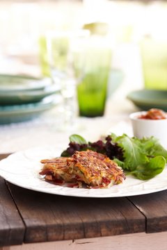 Plate of corned beef hash patties and salad leaves