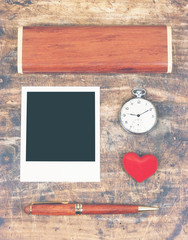 Wooden ballpoint and box, instant photo frame, red heart, old pocket watch on wooden table. Lay flat on old wooden table