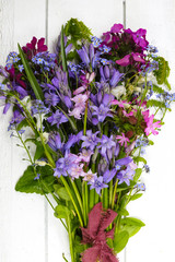 Bouquet with colorful forest flowers on white wooden background