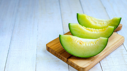 Fresh green melons sliced on wooden board place on table