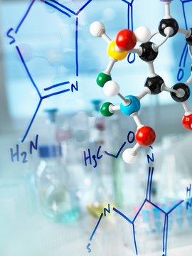 Ball and stick molecular model with formula of new drug written on glass