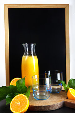 chalk board, and fresh orange juice in glasses and carafe
