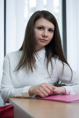 sexy girl in the office near the window reading a document on the table