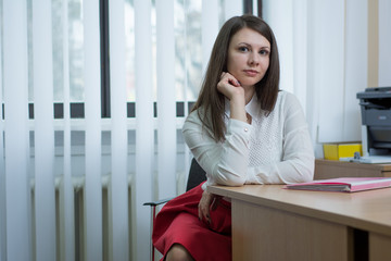 sexy girl in the office near the window reading a document on the table