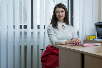 sexy girl in the office near the window reading a document on the table