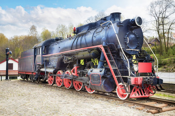 Fototapeta na wymiar Old steam locomotive on rusty old rails