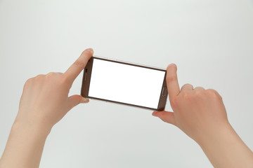 Big smartphone with empty blank display in hands isolated on the white background
