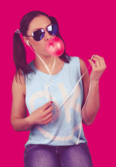 Funny girl wearing sunglasses with bubble of chewing gum