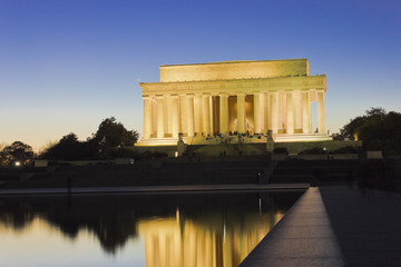 Night time view of the illuminated Neoclassical temple, the Lincoln Memorial with it's reflection on the surface of the Reflecting Pool, National Mall & Memorial Parks, Washington DC