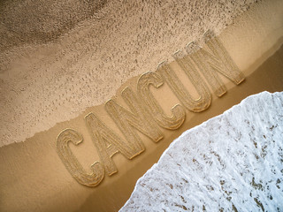Cancun written on the beach