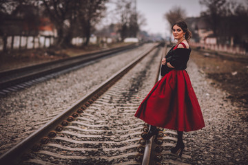 Beautiful Woman in Historical Garment Standing on the Abandoned Railway Station. Book Cover Concept.