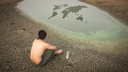 Water crisis world map, man sit on cracked earth near drying wat