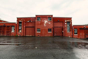 Old red brick industrial building and parking lot.