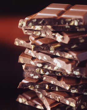 Stack of broken chocolate with hazelnuts, close-up
