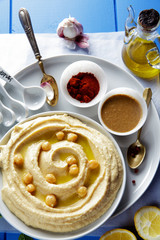Obraz na płótnie Canvas hummus and spices on a blue table