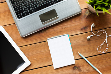 close up of notebook, laptop and tablet pc on wood