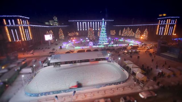 Ice resurfacing machine on outdoor ice rink at night christmas square time lapse