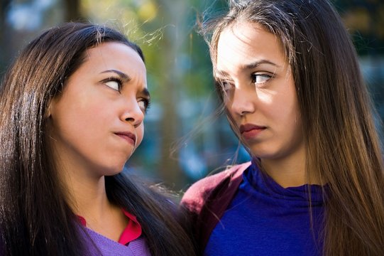 Twin sisters staring angrily at each other