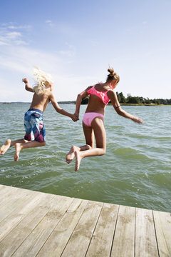 Boy And Girl Jumping Into Water