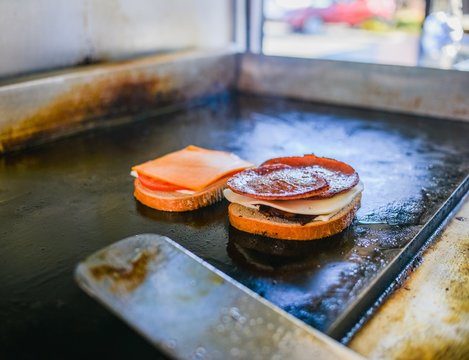 Pork roll sandwich cooking on catering van griddle