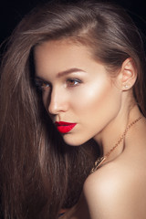 Fototapeta premium Beautiful young model with red lips and red manicure.Beauty Woman with Perfect Makeup. Beautiful Professional Holiday Make-up. Red Lips . Beauty Girl's Face on red background. Glamorous Woman