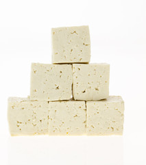 Tofu cut into cubes, isolated on white background.
