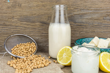 Soy mayonnaise, soy milk,tofu, lemon and soybeans, on wooden background
