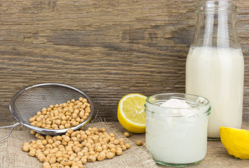 Soy mayonnaise, soy milk, lemon and soybeans, on wooden background
