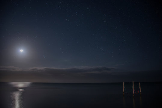 Starry sky and full moon illuminate iconic hammocks over waters, Isla Holbox, Mexico