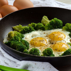 Broccoli and eggs cooked with spices in a pan