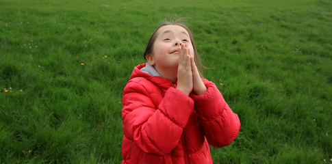 Portrait of beautiful girl praying in the park