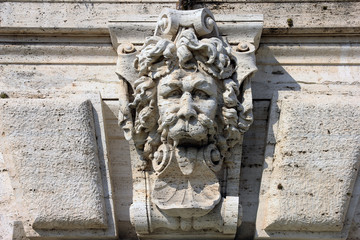 medieval roman stone sculpture on the wall of building in form o