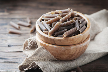 Uncooked italian buckwheat pasta on the wooden table
