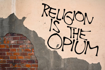 Handwritten graffiti Religion Is The Opium sprayed on the wall, anarchist aesthetics. Appeal on atheism.