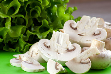 Raw mushrooms and lettuce on the table
